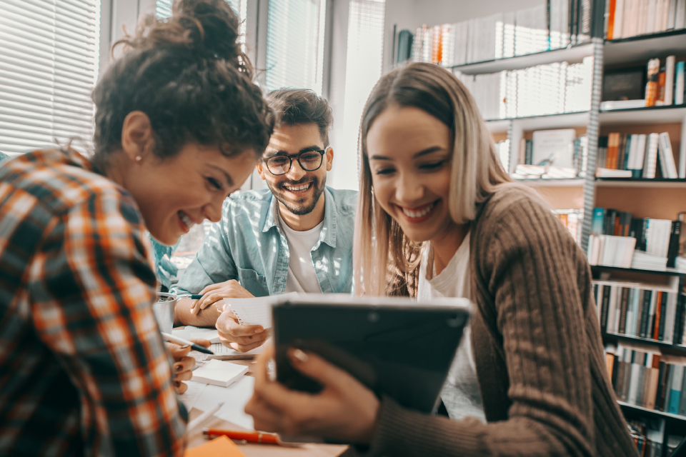 Jovens reunidos à volta de um tablet