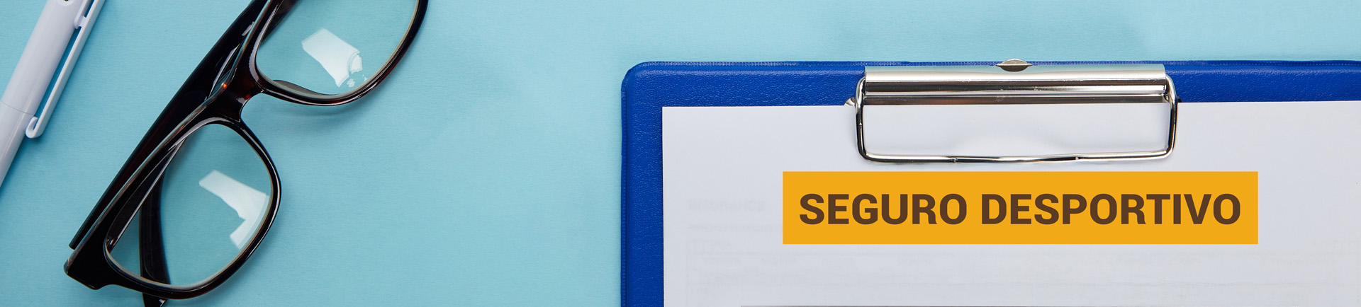 Lettering «Seguro desportivo» num caderno de apontamnetos, óculos e caneta