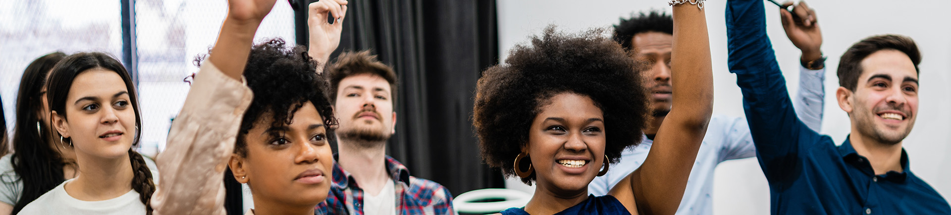 Grupo de jovens com a mao direita no ar.