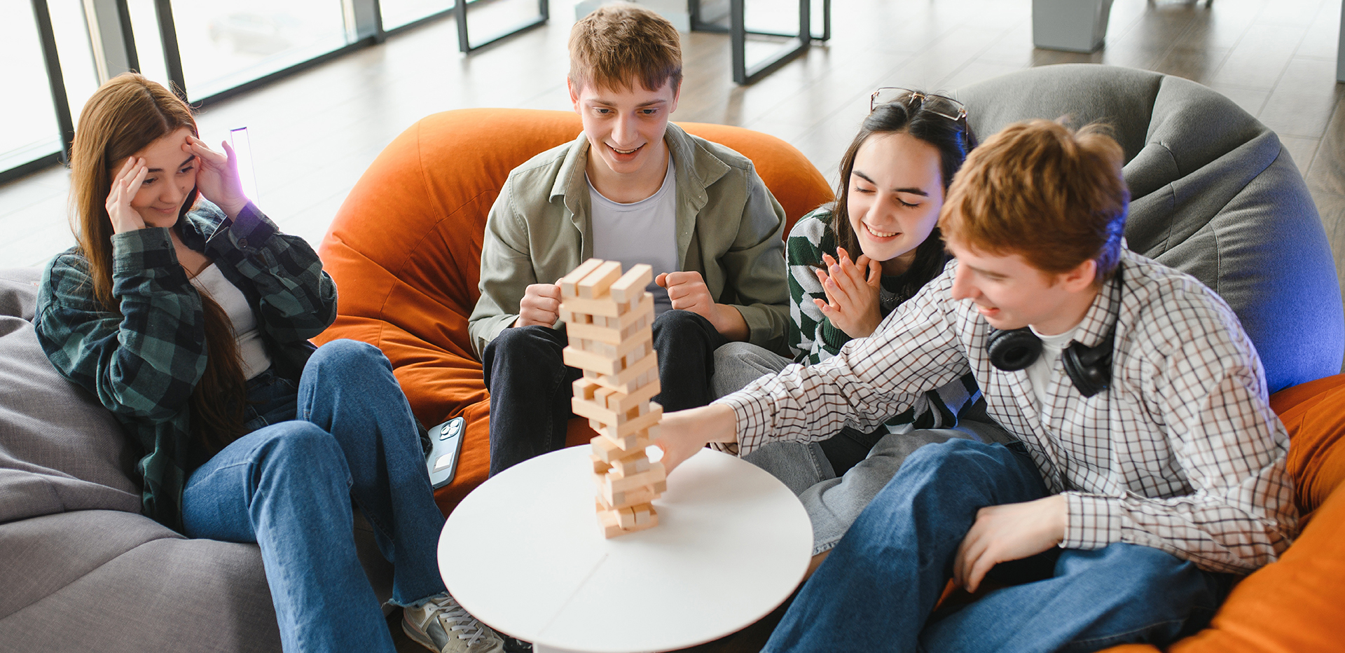 Jovens a jogar jenga à volta de uma mesa