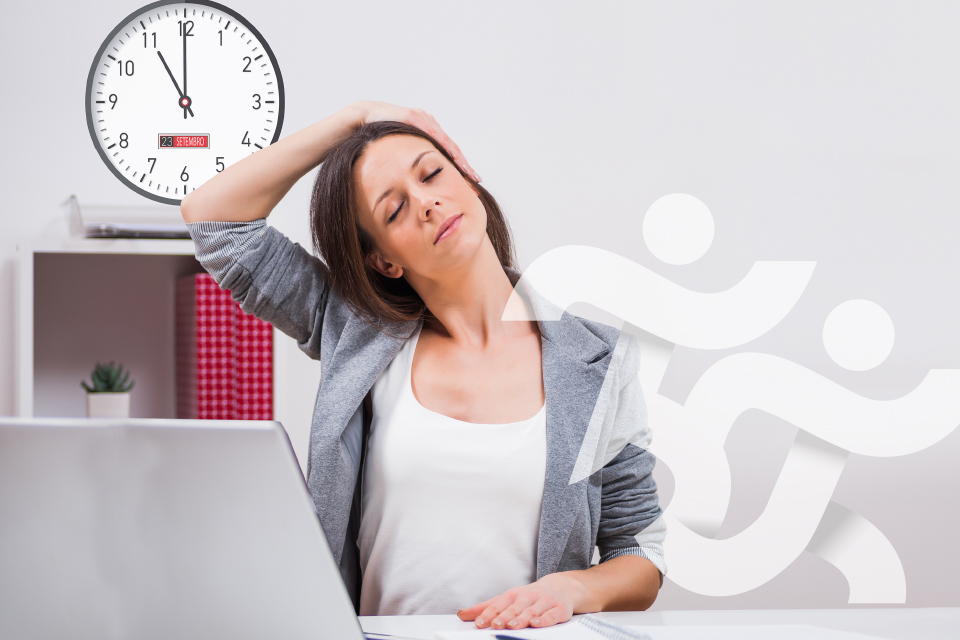 Mulher a alongar o pescoço enquanto está sentada na secretária