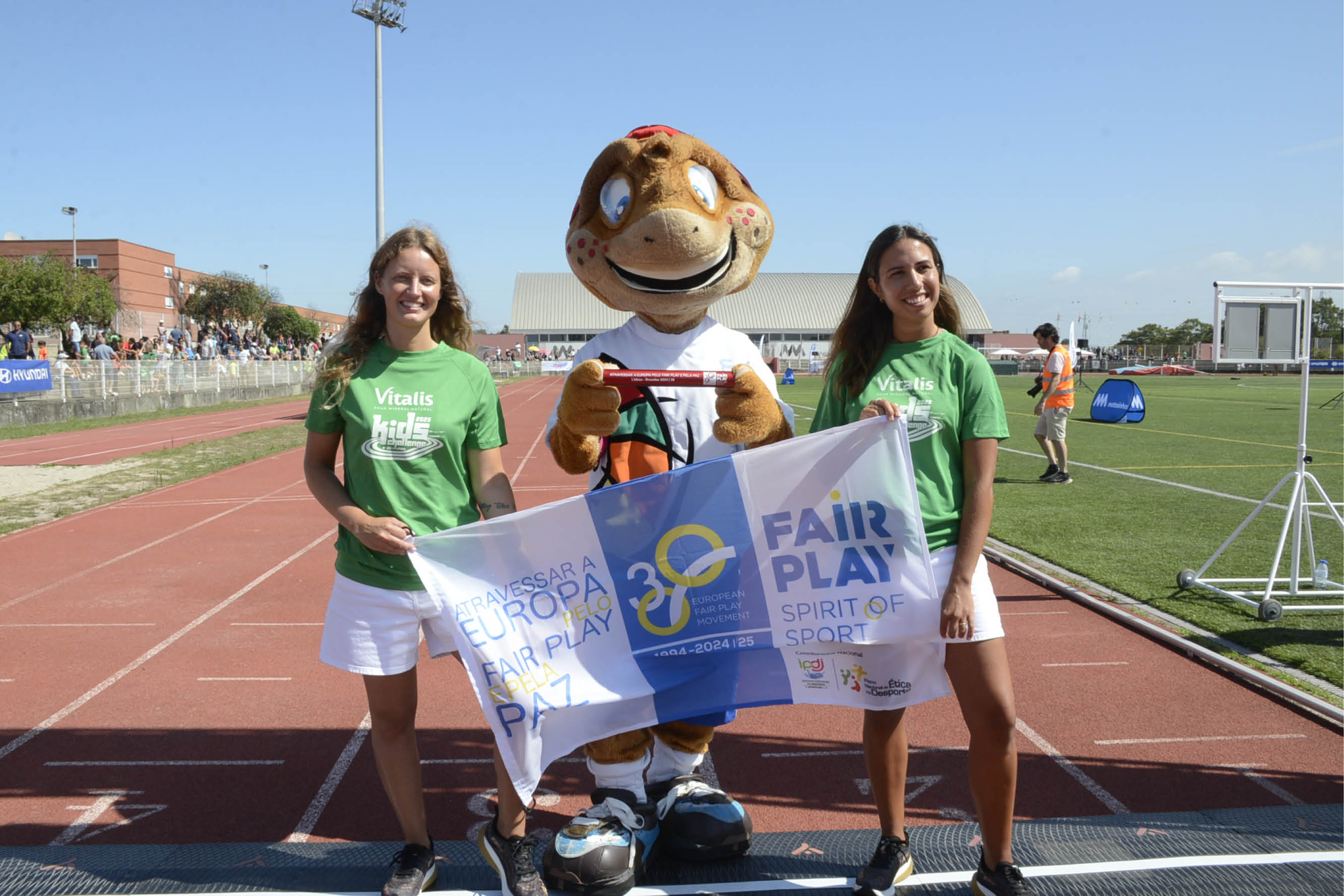 fotografia de atletas a segurar uma bandeira