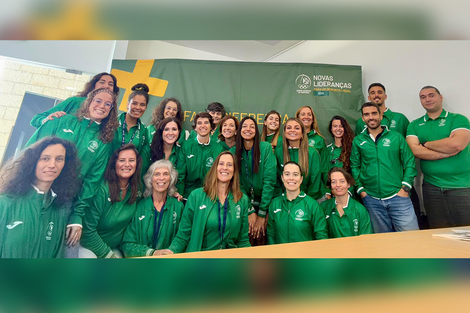 Participantes do Programa Novas Lideranças  Para um Desporto mais Igual posam para uma fotografia de grupo em frente ao painel institucional da iniciativa.