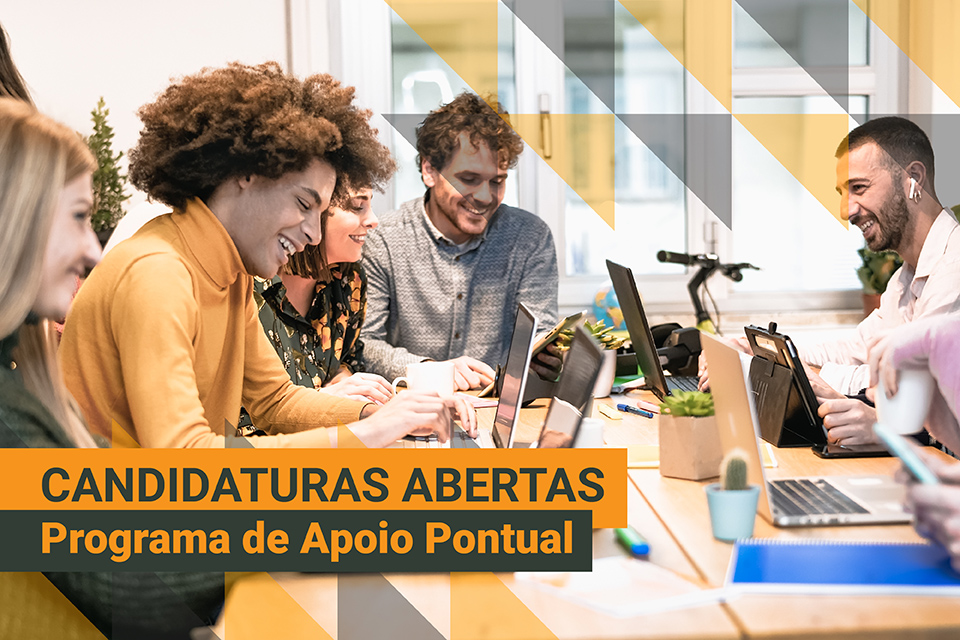 grupo de jovens sentados numa mesa, com computadores