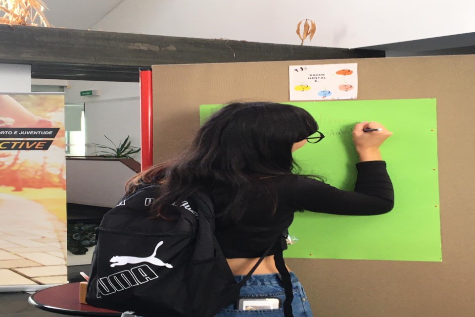 jovem a escrever em cartolina com frases/pensamentos