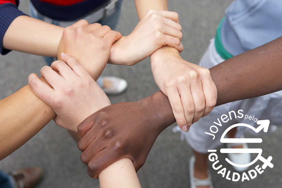 conjunto de mãos de jovens unidas em circulo com o logotipo da distinção