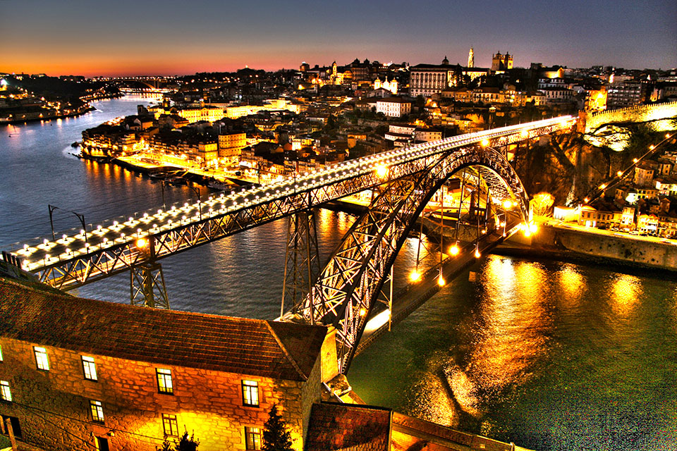 imagem noturna do Douro ladeado pelo Porto e Gaia