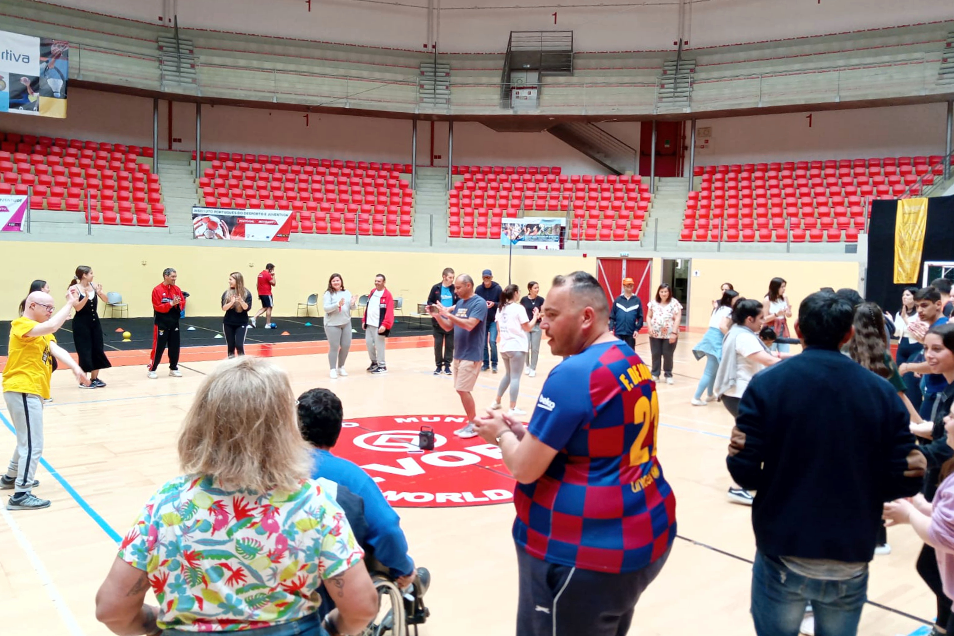 Várias pessoas com necessidades especiais, e técnicos, na Arena D'Évora, na atividade de dança.
