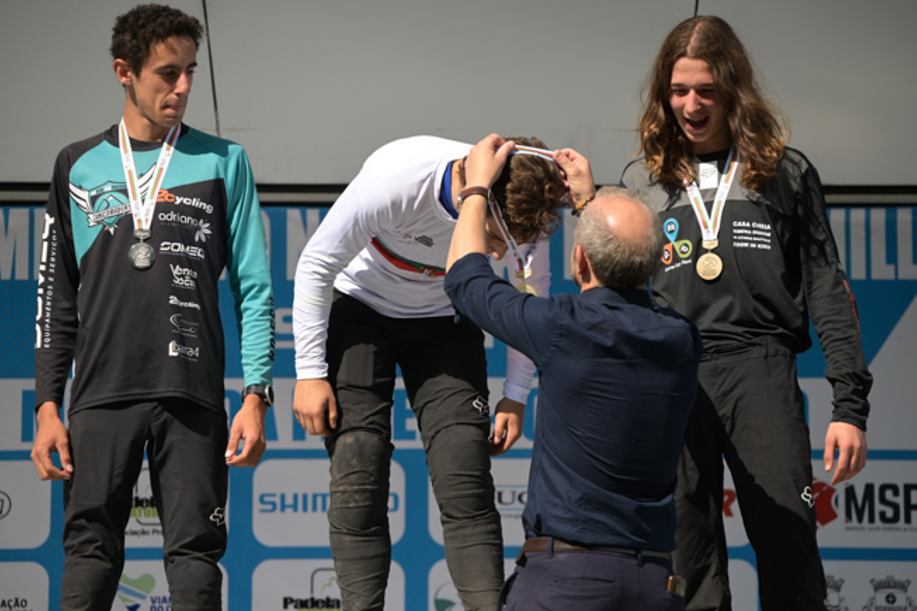 Álvaro Pestana no pódio a receber a medalha de primeiro classificado, com Matias Camacho e Pedro Câmara, segundo e terceiro classificados, já com as suas medalhas ao pescoço.