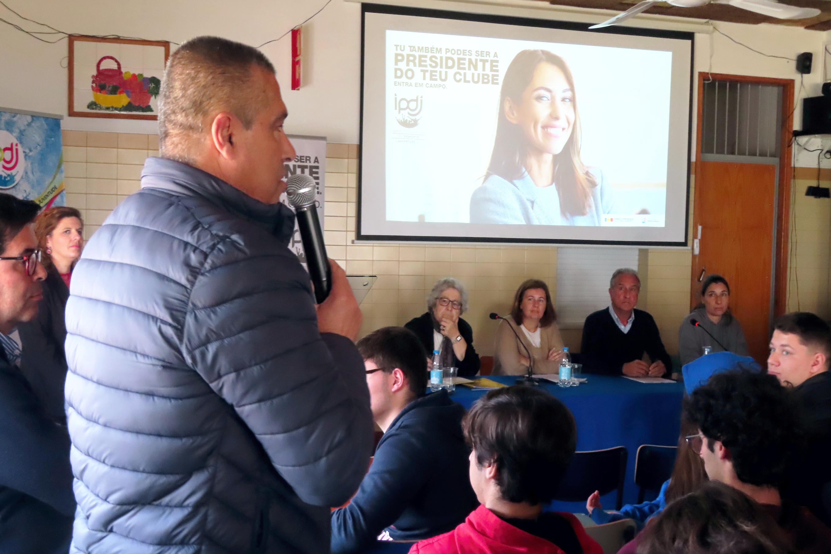 Professor a colocar uma questão sobre a iniciativa às convidadas, com a atenção dos participantes.