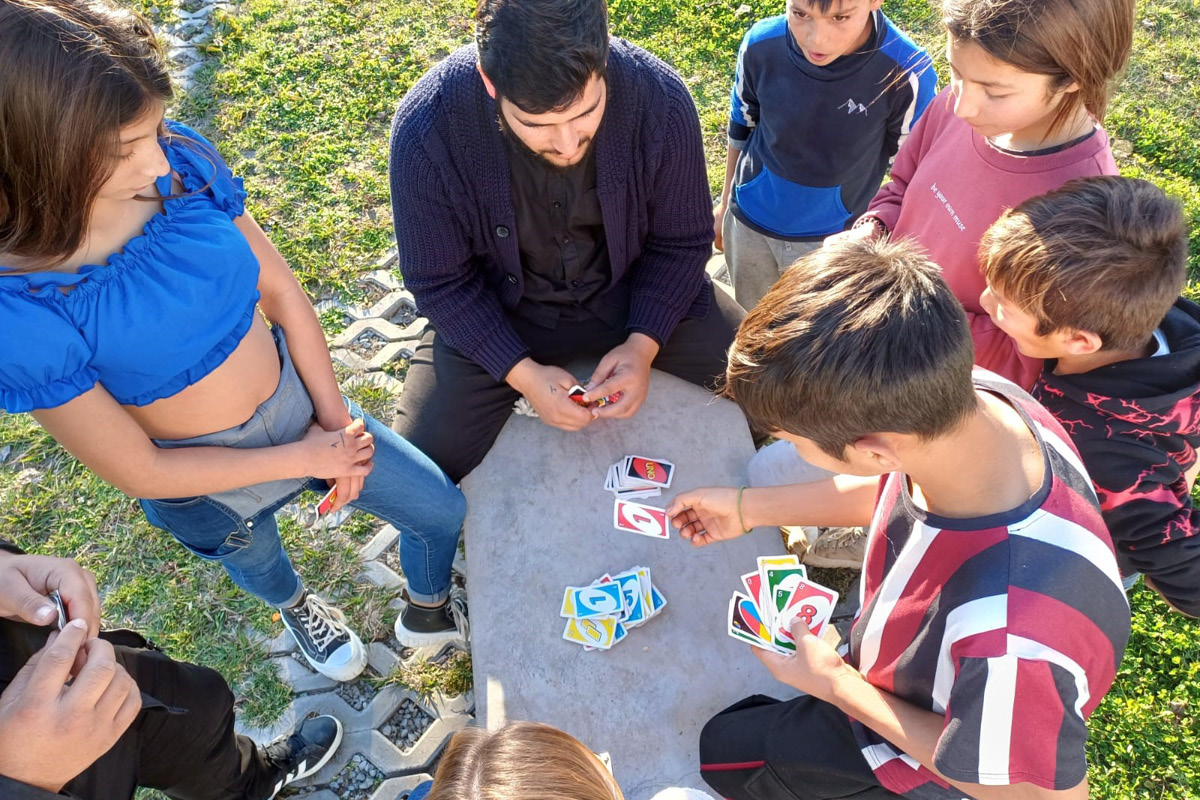 conjuntos de jovens da comunidade cigana a jogar um jogo de cartas na rua