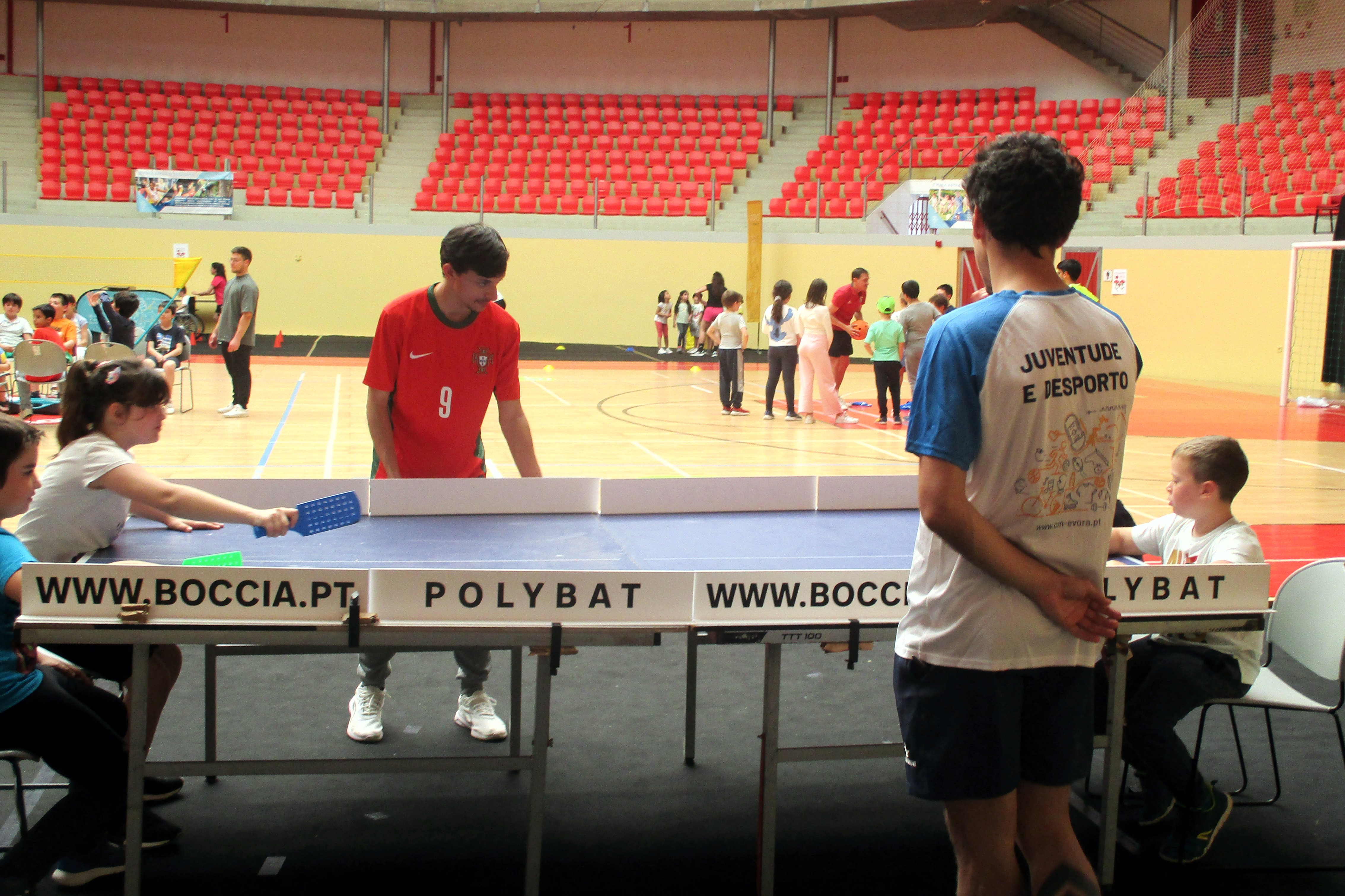 Crianças na Arena D'Évora a jogarem ping pong, com o apoio de alunos da Universidade de Évora.