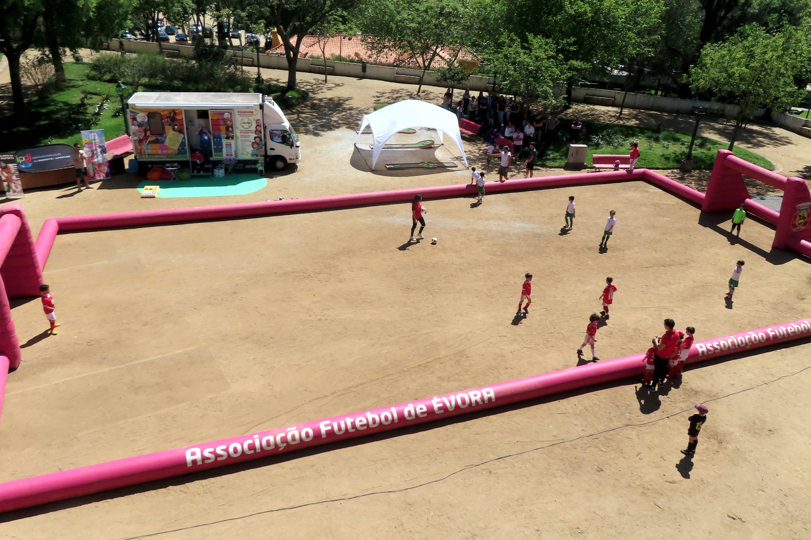 Crianças no Jardim Público de Évora a jogarem futebol num campo insuflável, ao pé da Unidade Móvel Cuida-te+.