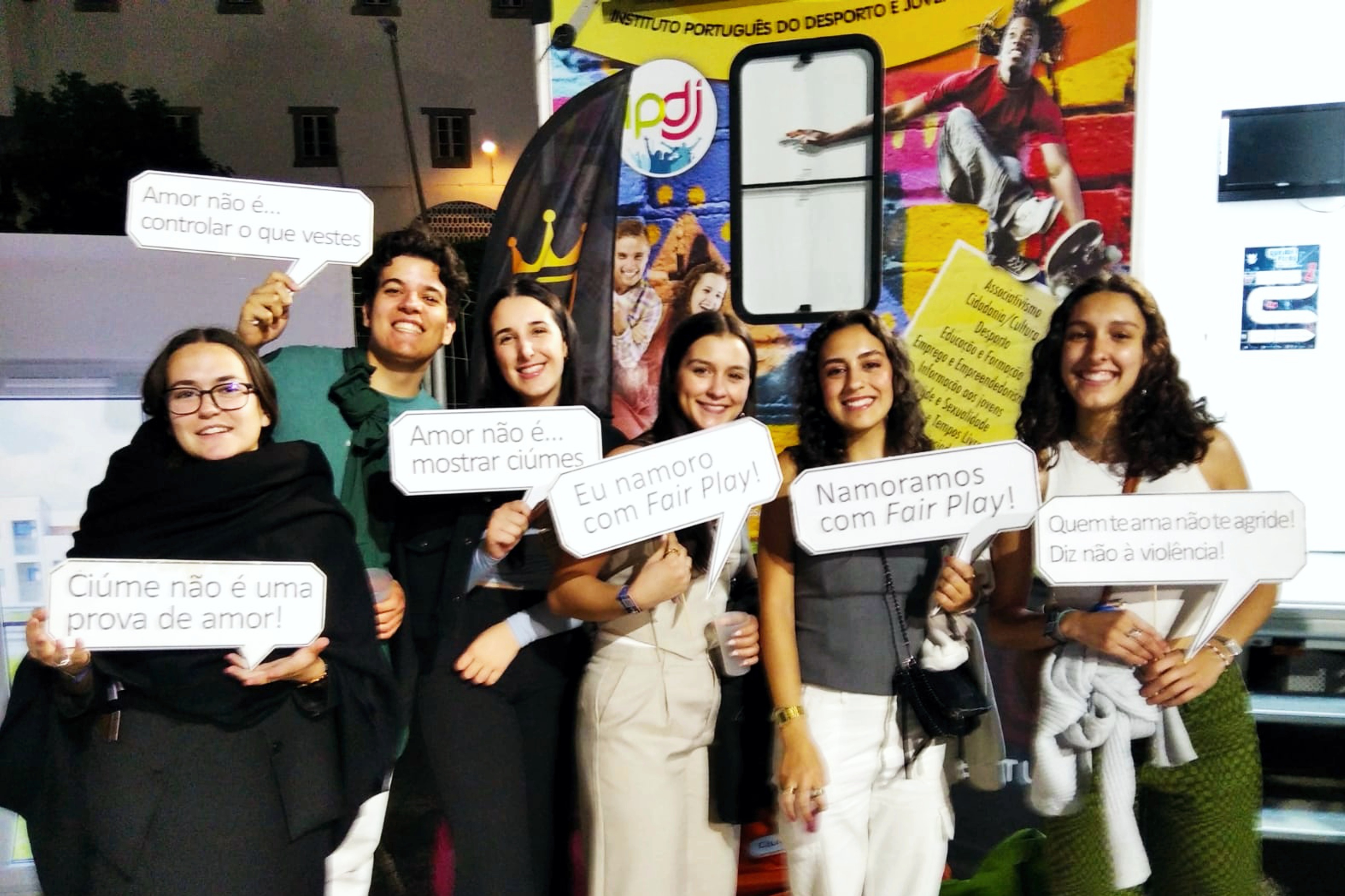 Cinco jovens (1 rapaz e 4 raparigas), junto à Unidade Móvel Cuida-te+, com 1 «balão» cada um/a, sobre o projeto «Namorar com Fair Play».