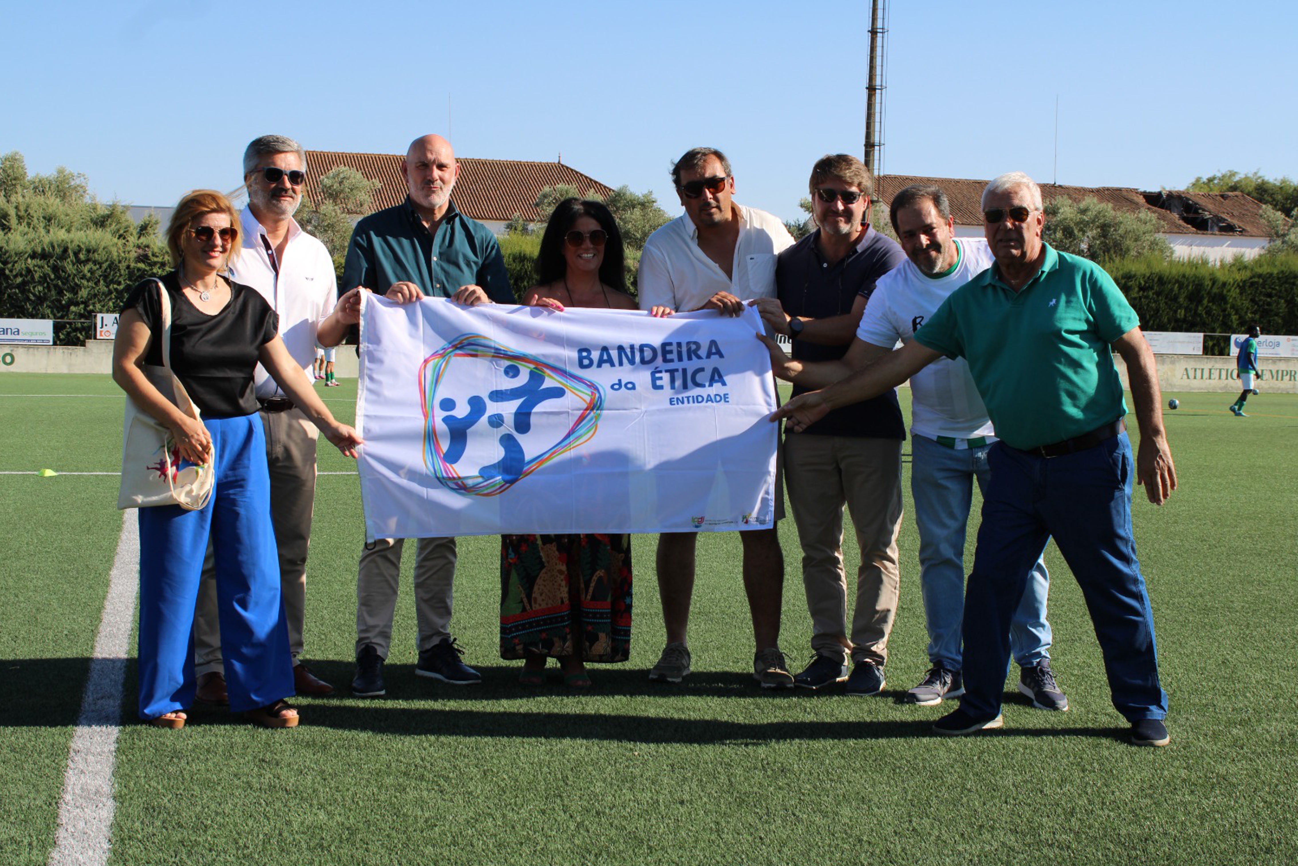 diretor regional do Alentejo do IPDJ, Miguel Rasquinho, presidente do Município de Reguengos de Monsaraz, Marta Prates, do presidente do Atlético Sport Clube, Jorge Segurado, do responsável pelo Departamento de Ética do Atlético Sport Clube, Paulo Escoval, do presidente da Junta de Freguesia de Reguengos de Monsaraz, Pedro Mata, do presidente da Assembleia, Joaquim Passadindas, e da técnica de desporto do IPDJ Alentejo, Andreia Peixe, a segurarem a Bandeira da Ética.