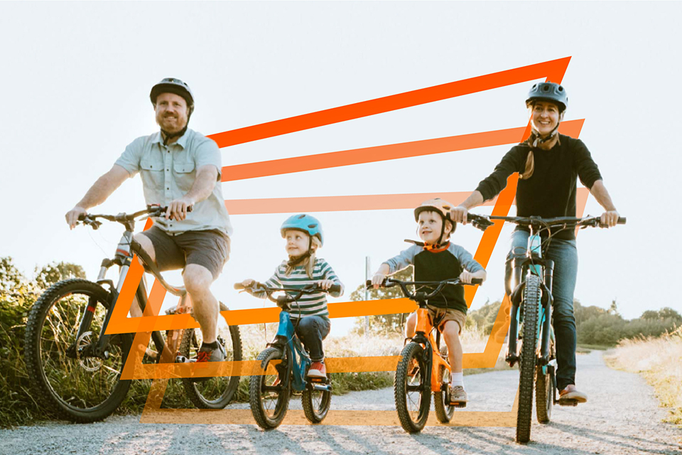 Cartaz com fundo branco, com a imagem de um homem, duas crianças e uma mulher, a andarem de bicicleta no campo.