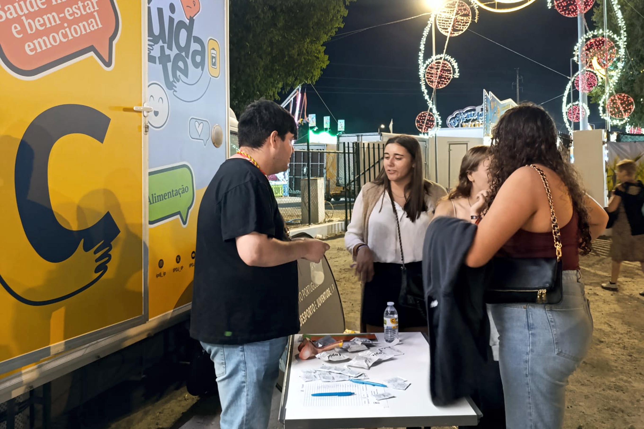 Jovens junto à Unidade Móvel Cuida-te a participarem nas atividades nas atividades dinamizadas pelo profissional de saúde Cuida-te, tendo também como «pano» de fundo o espaço da Feira da Luz.
