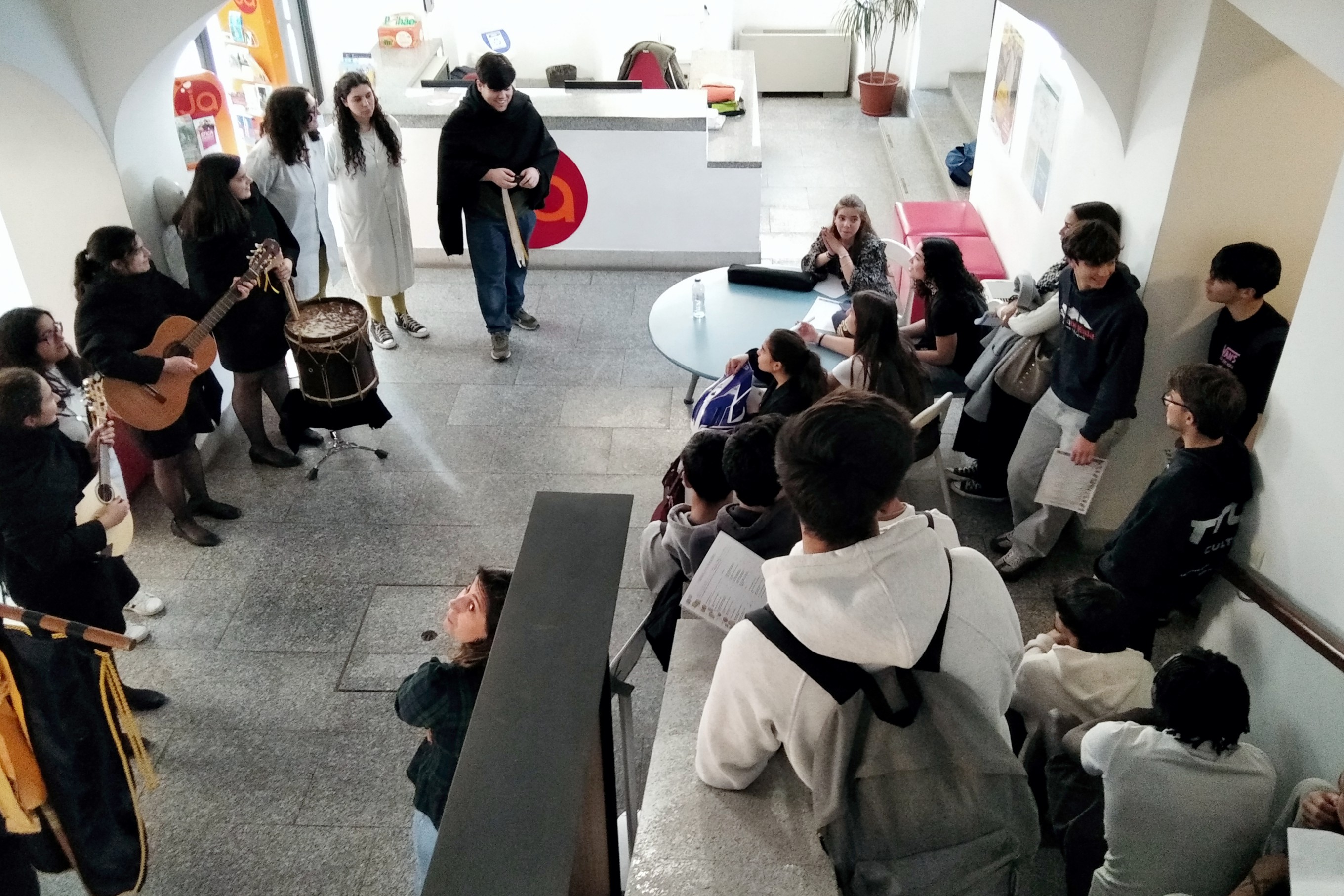 Jovens na Loja Loja Ponto JA a assistirem à atuação da Tuna da Escola Superior de Enfermagem São João de Deus, após a realização de atividades no âmbito do Programa Cuida-te.