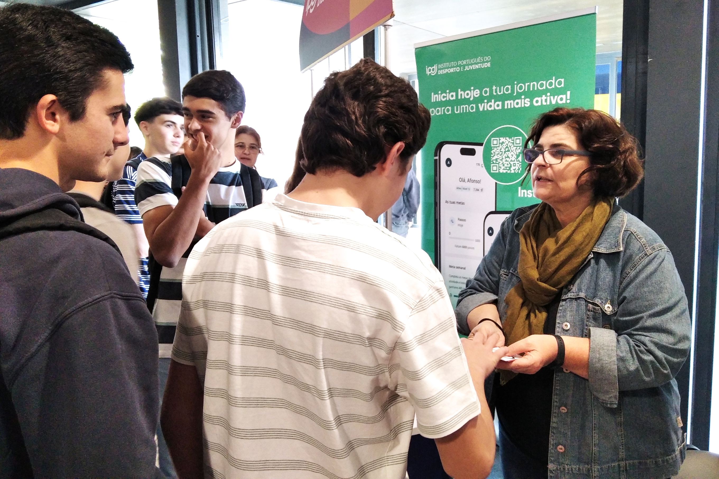 Jovens junto ao stand do IPDJ a participarem nas atividades dinamizadas pela técnica do IPDJ de Évora, Maria Gabriela Segurado.
