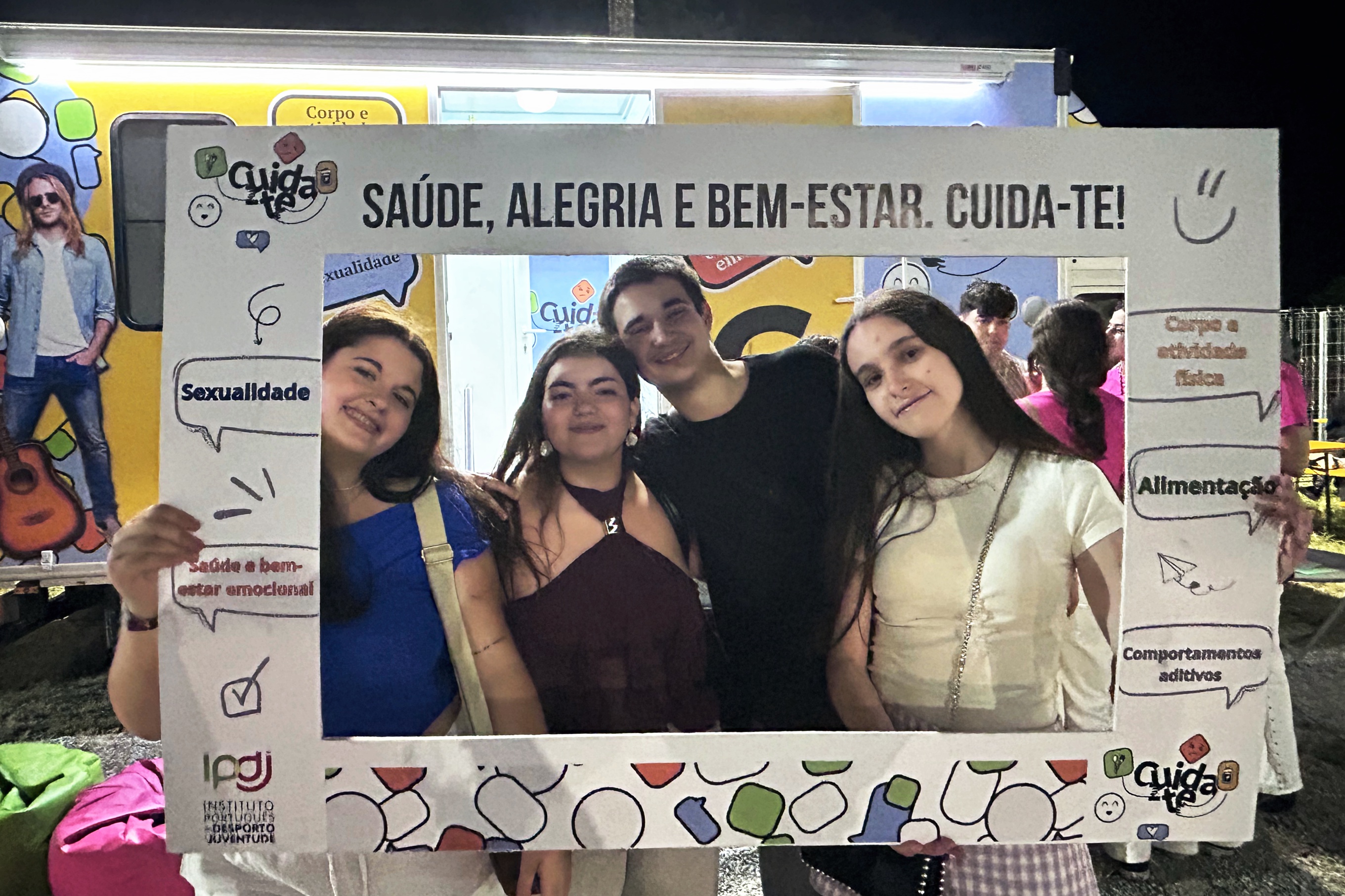 Imagem com quatro jovens, na «janela» do Programa Cuida-te, junto à Unidade Móvel.