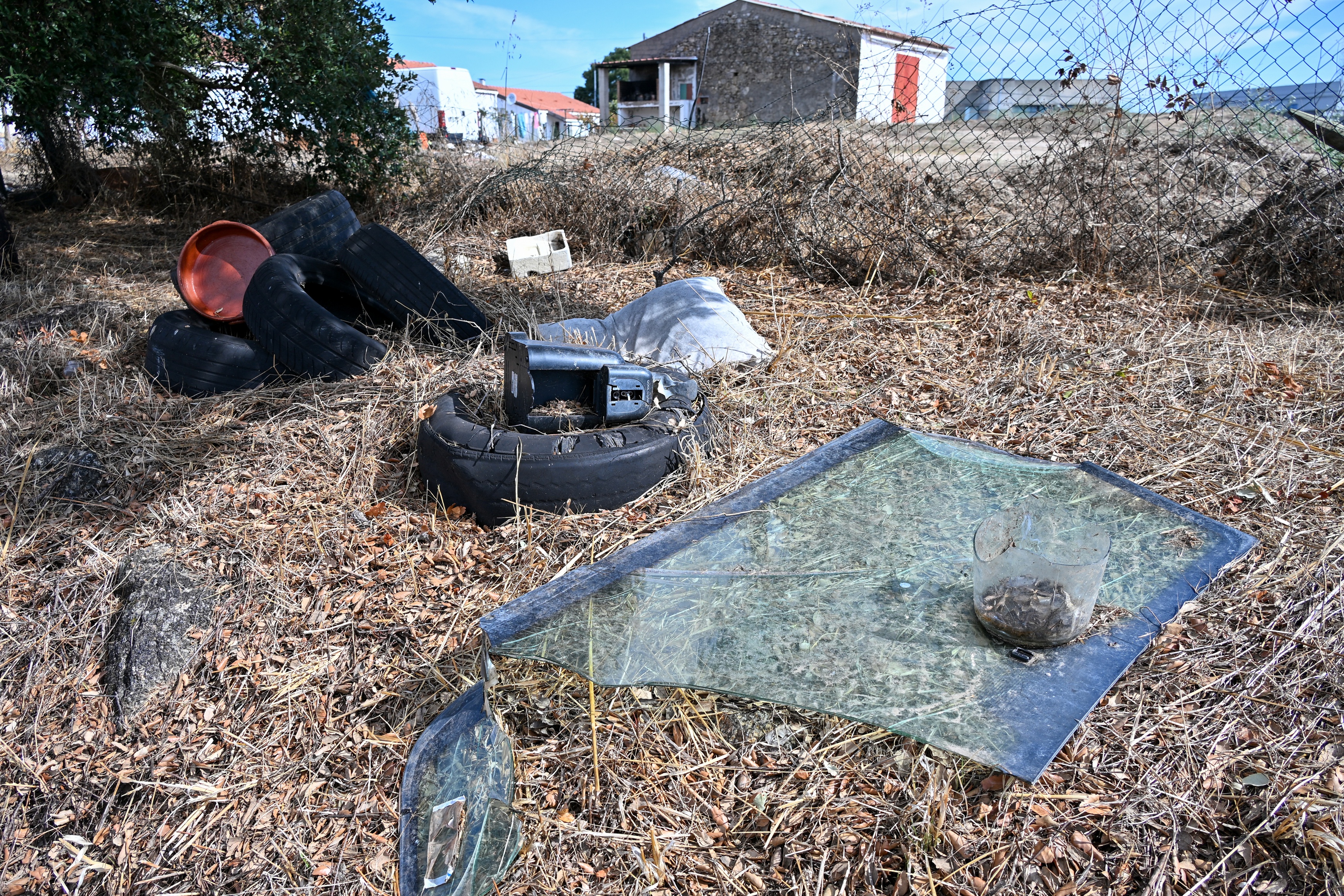 Lixo espalhado pelo campo, nomeadamente, pneus, pára-brisas, alomofadas, e vários utensílios em plástico.