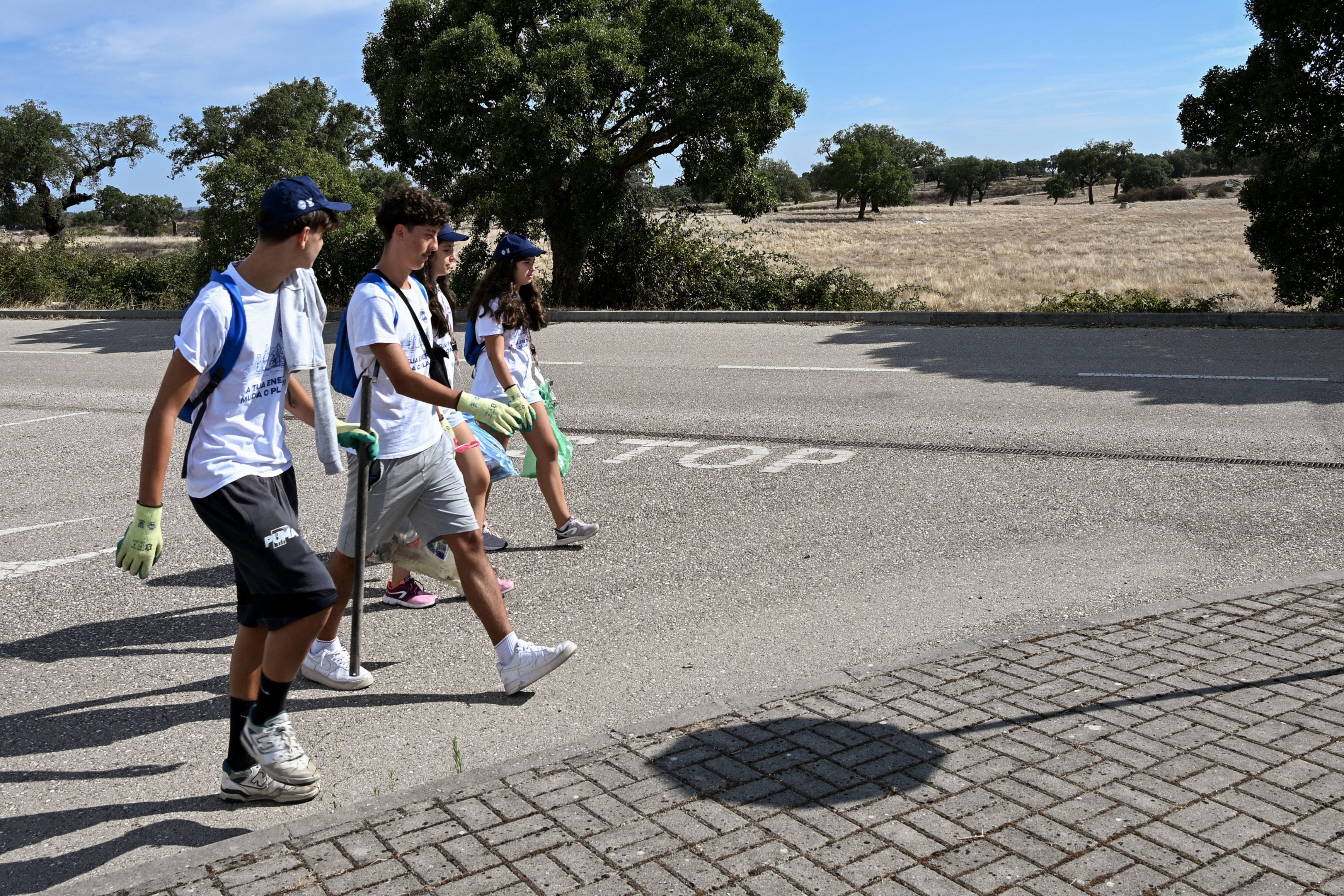Quatro jovens voluntários com o lixo recolhido, durante a atividade, na companhia